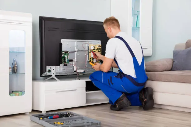 Tehnician reparând TV la domiciliu